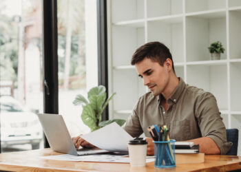 caucasian business man working with documents and laptop.