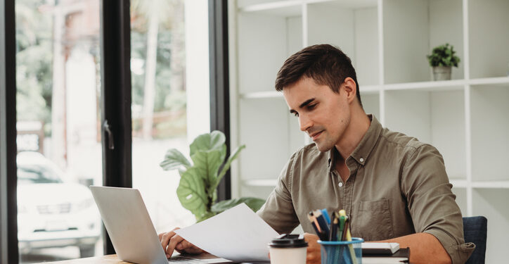 caucasian business man working with documents and laptop.